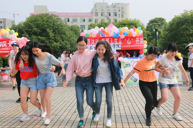 图为大学生正在进行“两人三足”趣味活动。